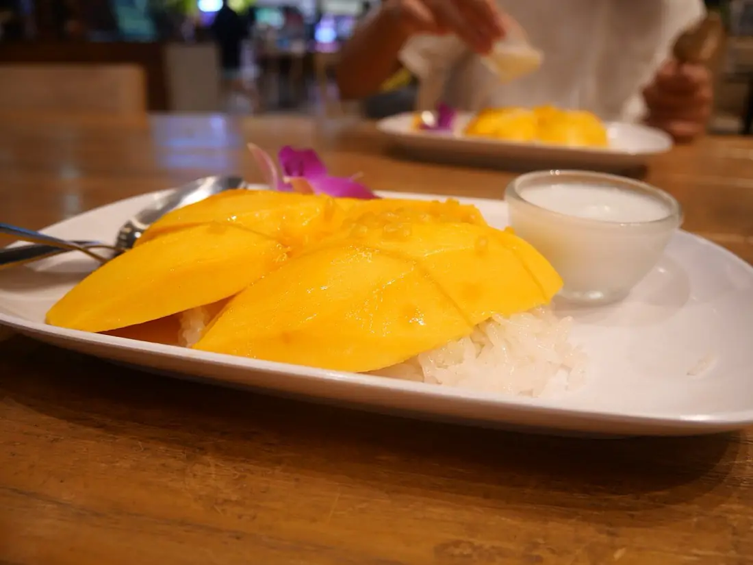 Mango with sticky rice and coconut cream on a plate