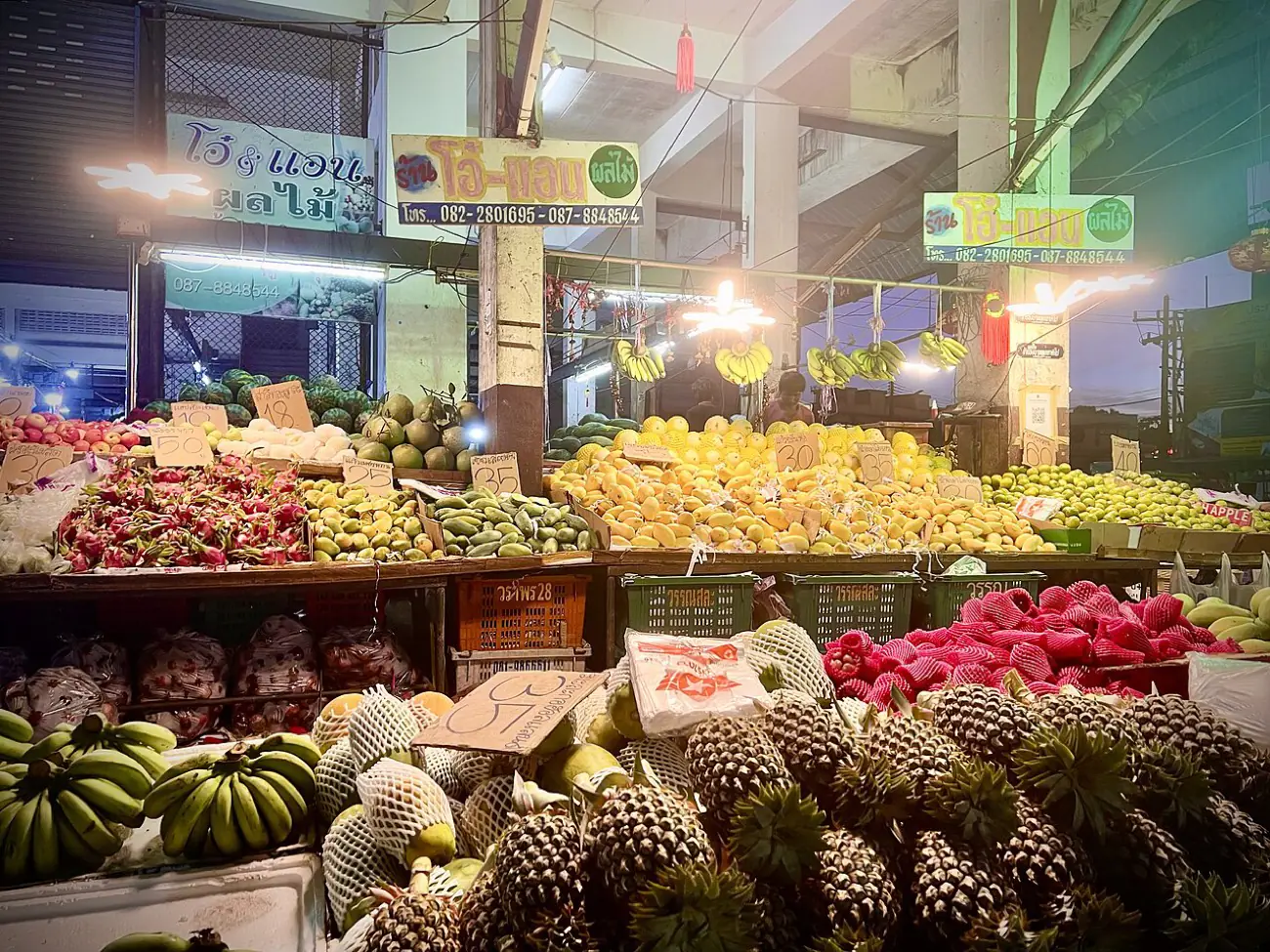 Stacked tropical fruit and produce on a morning market stall in Krabi