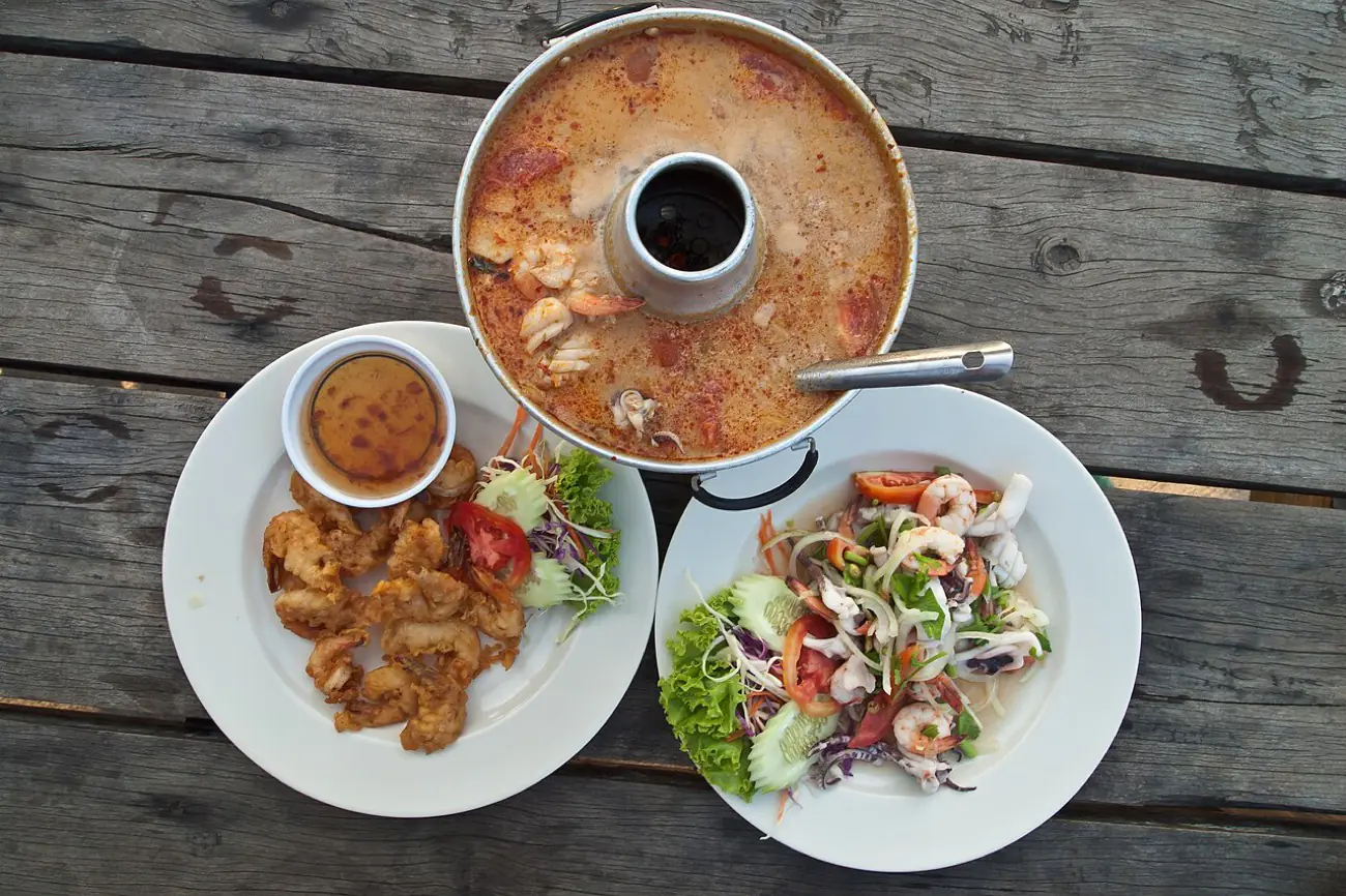 A spread of grilled Thai seafood dishes on a table